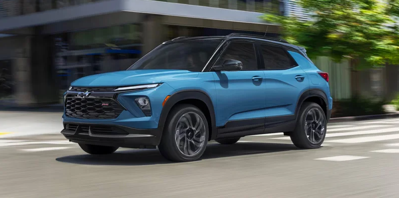 A blue Chevy Trailblazer driving down the road.