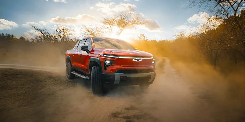 Someone driving a 2026 Chevrolet Silverado EV down a dirt road.