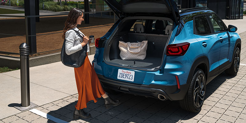2026 Blue Chevrolet Trailblazer parked road side, Open bootspace, person keeping the luggage