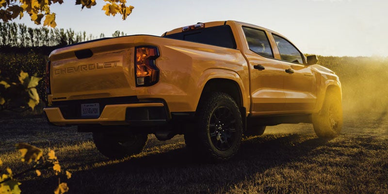A yellow 2026 Chevrolet Colorado parked on a grass hill.